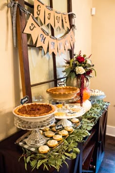 a buffet table with pies and cupcakes on it