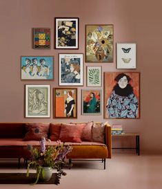 a living room filled with lots of art on the wall above a couch and coffee table