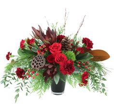 a vase filled with red flowers and greenery