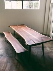 a wooden table sitting in front of a window on top of a hard wood floor