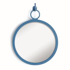 a round mirror hanging on the wall with a blue ring around it's edge