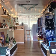 a room filled with lots of clothes and other items on shelves next to a window