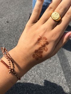 a woman's hand with a smiley face on it and a flower design on the wrist