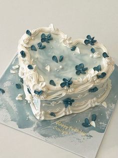 a heart shaped cake with blue flowers on it