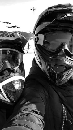 black and white photograph of two people wearing helmets