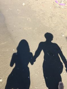 the shadow of two people holding hands