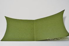 an empty green pillow sitting on top of a white table