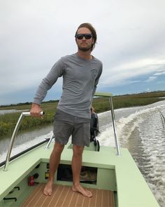 a man standing on the back of a boat