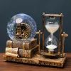 an antique clock and hourglass on a wooden table