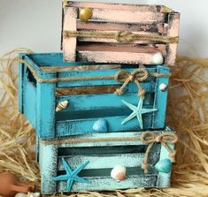 three wooden crates with seashells and starfish on them