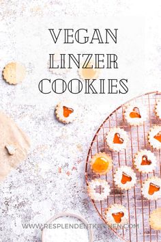 vegan linzer cookies on a cooling rack with powdered sugar and orange slices