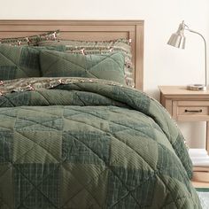 a bed with green bedspread and matching comforter