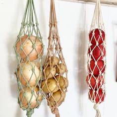 three hanging baskets filled with potatoes and onions next to a wall mounted hook on a door