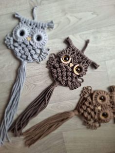 three crocheted owls with tassels on top of a wooden floor next to each other