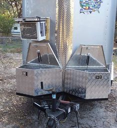 the back end of a silver trailer with two ovens on it's sides