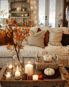 a living room filled with lots of furniture and candles on top of a coffee table