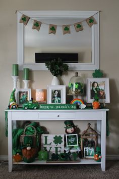 a st patrick's day table with shamrock decorations and pictures on the top shelf