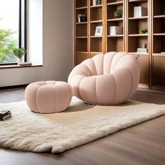 a pink chair and ottoman sitting on top of a rug in front of a bookcase