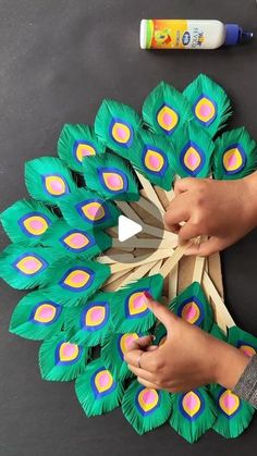 someone is making a paper peacock decoration