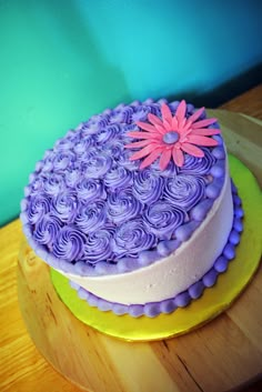 a cake with purple frosting and pink flowers on top