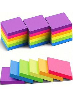 several different colors of sticky notes on a white background