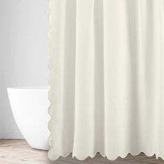 a white shower curtain with scalloped edges