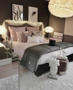 a large bed sitting in a bedroom next to two lamps and pictures on the wall