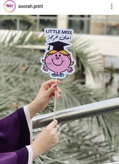 a person holding up a little miss piggy sticker