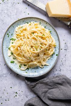 a plate of pasta with parmesan cheese on the side