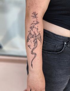 a woman's arm with a dragon tattoo on the left side of her body