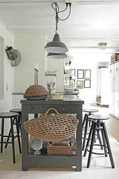 a kitchen island with stools and baskets on it