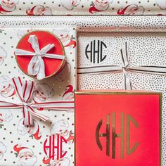 the wrapping paper is wrapped in red and white with gold monogrammings on it