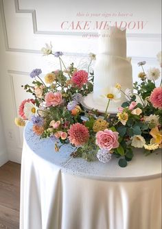 a white wedding cake with flowers on top