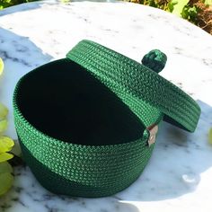 a green basket sitting on top of a marble table