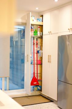 a kitchen with white cabinets and stainless steel refrigerator