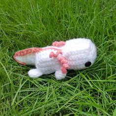 a crocheted stuffed animal laying on top of green grass with the words pattern below it