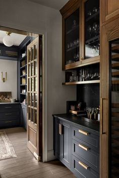 a kitchen with dark wood cabinets and black counter tops, along with an area rug on the floor