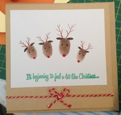 a christmas card with three reindeer heads on it