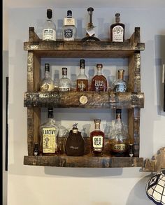 an old wooden shelf with liquor bottles on it