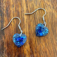 These earrings are handmade by me. They contain royal blue glitter mixed with resin and cured. The earring hardware is stainless steel. Please note that due to the handmade nature of the product, there may be slight variations between the two earrings. If you are local (Opelika/Auburn Alabama) and would like to pick up the earrings in person rather than paying for shipping, please use the coupon code LOCALPICKUP, and I will message you to arrange for a drop off/delivery of the earrings. Blue Handmade Heart Drop Earrings, Handmade Blue Heart Drop Earrings, Blue Heart-shaped Earrings With Ear Wire, Blue Glitter Dangle Earrings, Nickel-free Blue Heart Earrings, Blue Nickel-free Heart Earrings, Blue Nickel-free Heart Earrings As Gift, Nickel-free Blue Heart Earrings As Gift, Nickel-free Blue Heart Earrings For Gift