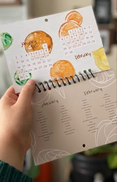 a person holding up a calendar with oranges on it