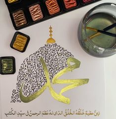 an arabic calligraphy is displayed on top of a paper with gold foil and watercolors