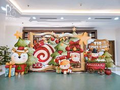 christmas decorations are displayed on the floor in front of a large sign with santa's sleigh and candy canes