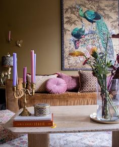 a living room filled with lots of furniture and flowers on top of a coffee table