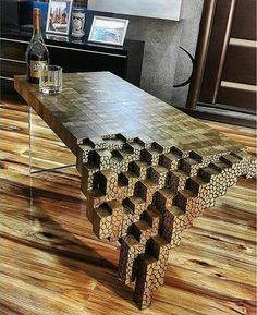 a table made out of wooden blocks and wine glasses on the top, in a room with wood flooring