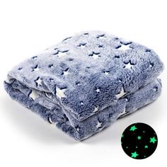 a blue blanket with stars on it and a green glow in the dark sticker