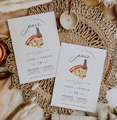 two pizza slices are on top of the wedding stationery, next to some candles