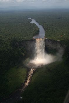 an aerial view of a large waterfall in the middle of trees and water flowing down it's sides