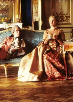 two people sitting on couches in an ornate room