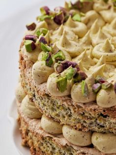 a close up of a cake on a plate with icing and nuts around it